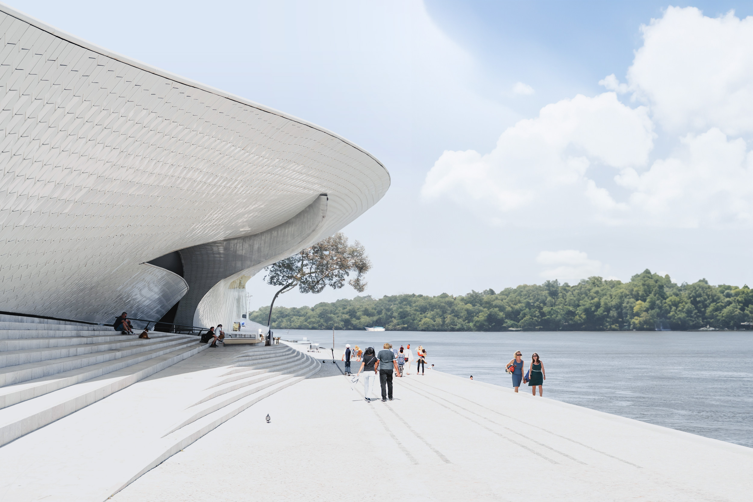 Futuristisk byggnad med vit, svepande arkitektur till vänster, flankerad av människor som promenerar på en bred gångyta. I bakgrunden syns en flod och grönskande träd under en delvis molnig himmel.