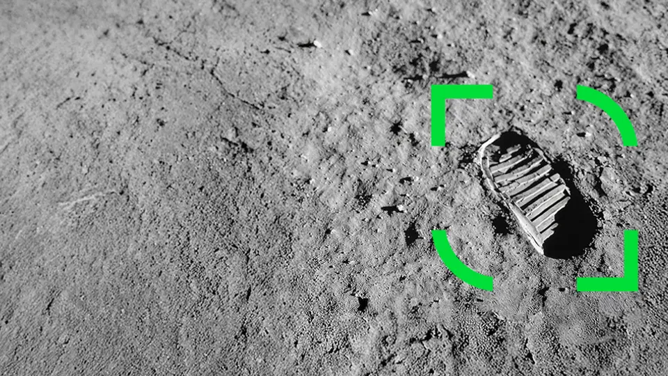 Fotavtryck i månens yta med ett grönt markeringsfokus runt avtrycket, omgiven av grå, kornig terräng.
